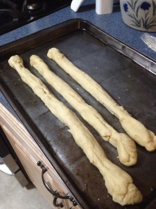 First, cut the bread dough into 6 sections and stretch the section out into long strips.