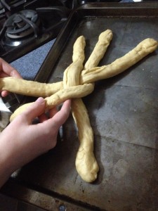 Braid the sections together, trying not to tear the dough. When you come to the end of the sections, tuck the ends under the braid. 